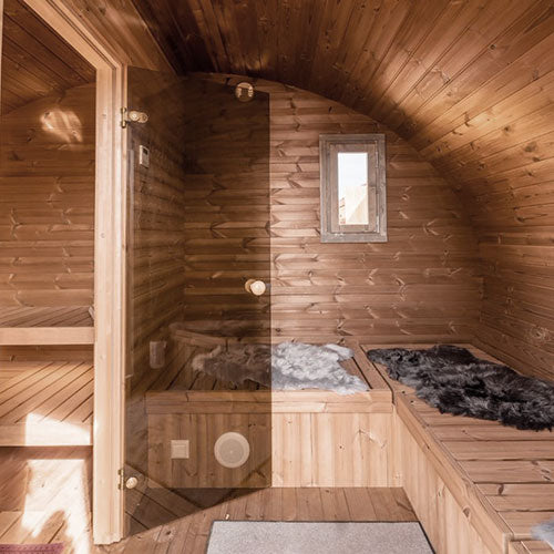 Wooden sauna with wooden walls and floor, featuring a small window.